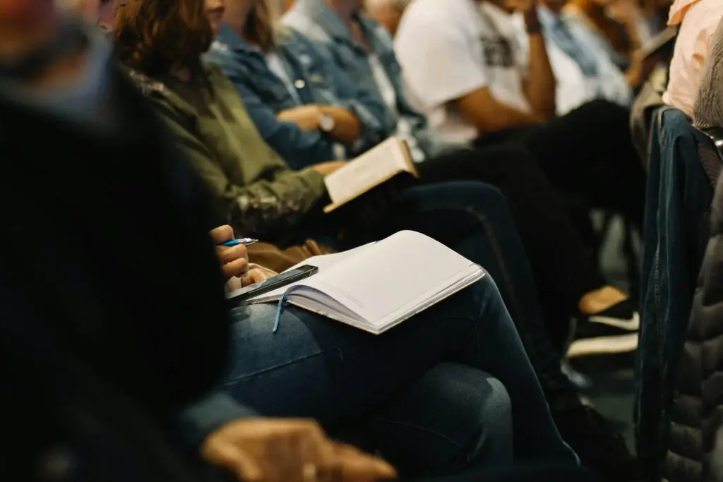 group of people listening and writing in notebooks during a workshop