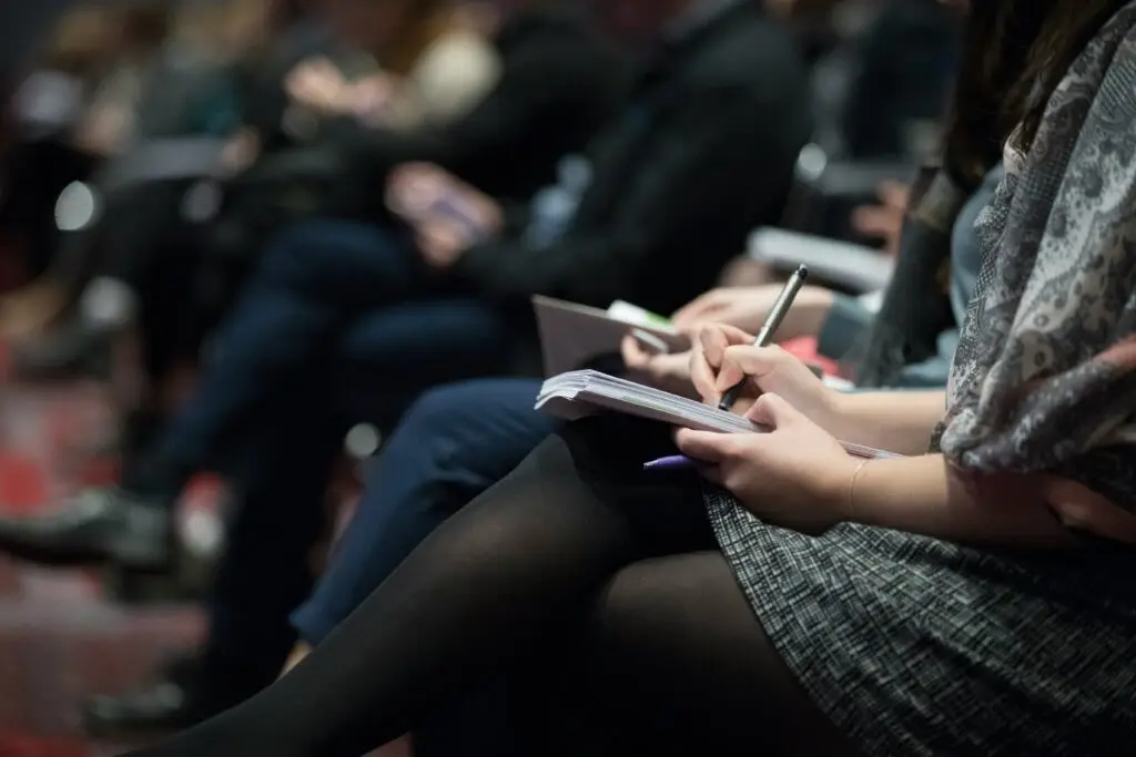 people sitting in a seminar taking notes during a training session